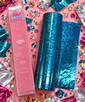 Thin Ice blue crackle holographic toner reactive foil roll with Ugly Betty Confetti packaging, flat lay on pink