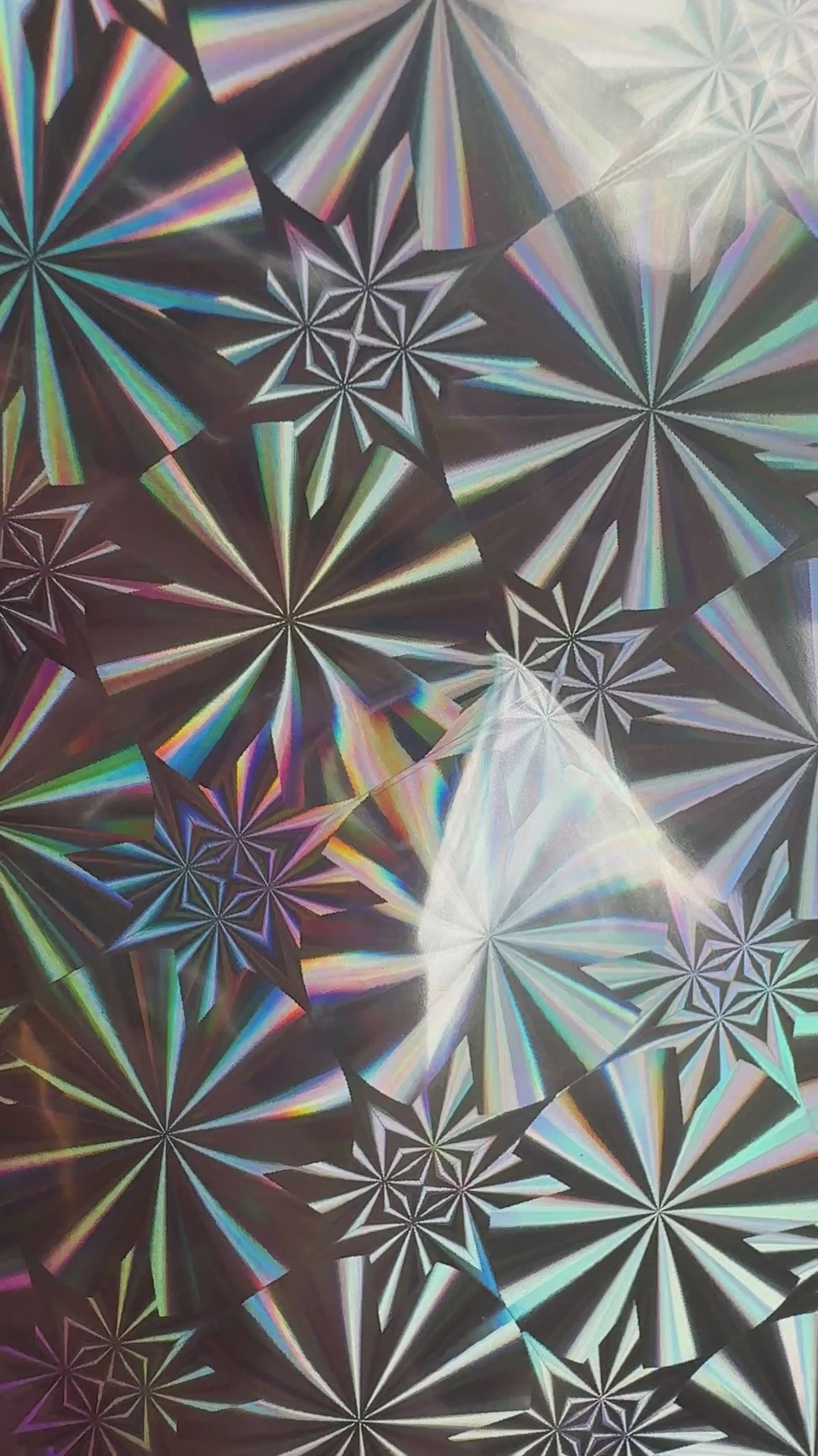 Silver Screen silver starburst holographic toner reactive foil tilting in the light, the starbursts appearing to move