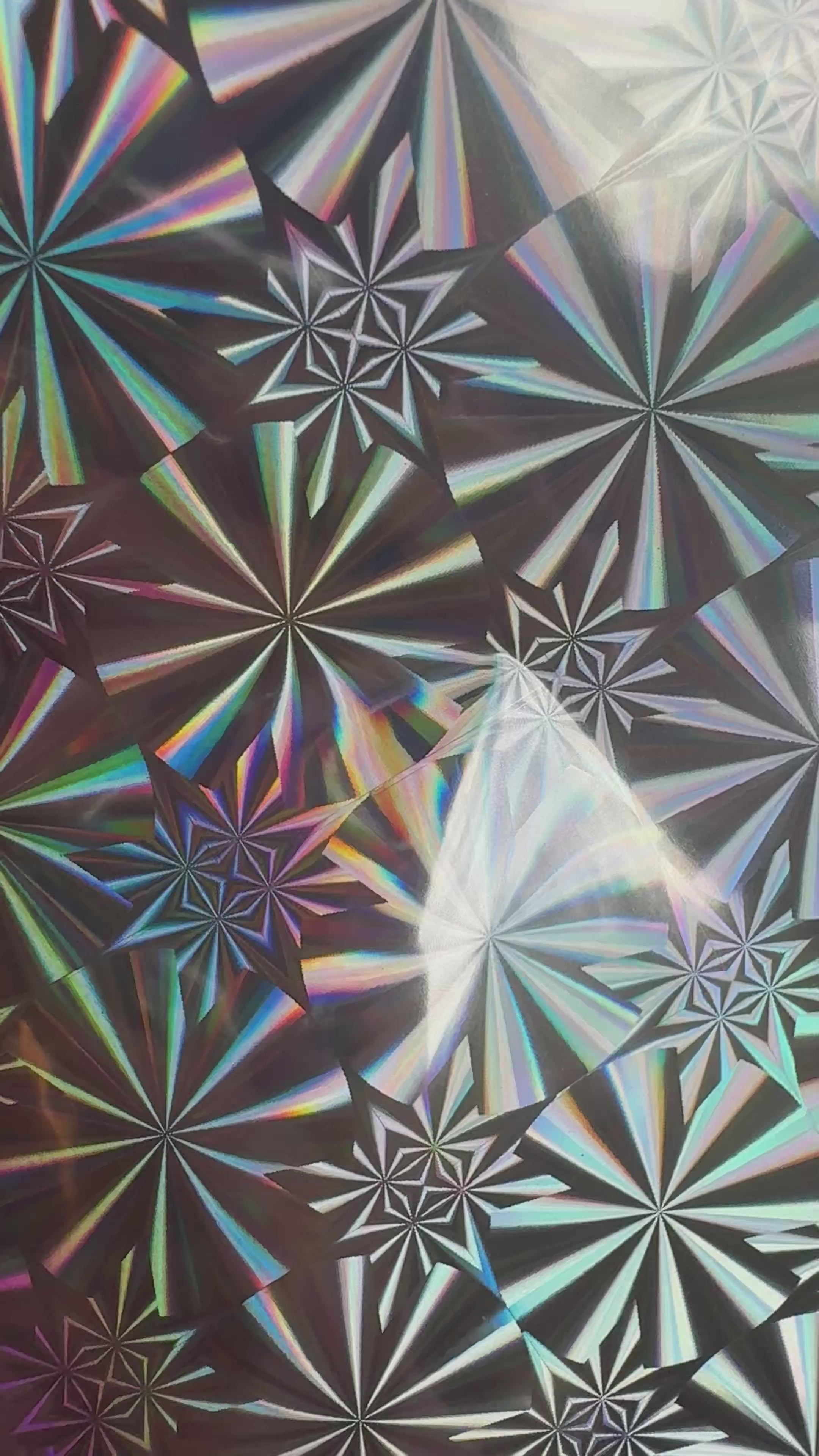 Silver Screen silver starburst holographic toner reactive foil tilting in the light, the starbursts appearing to move