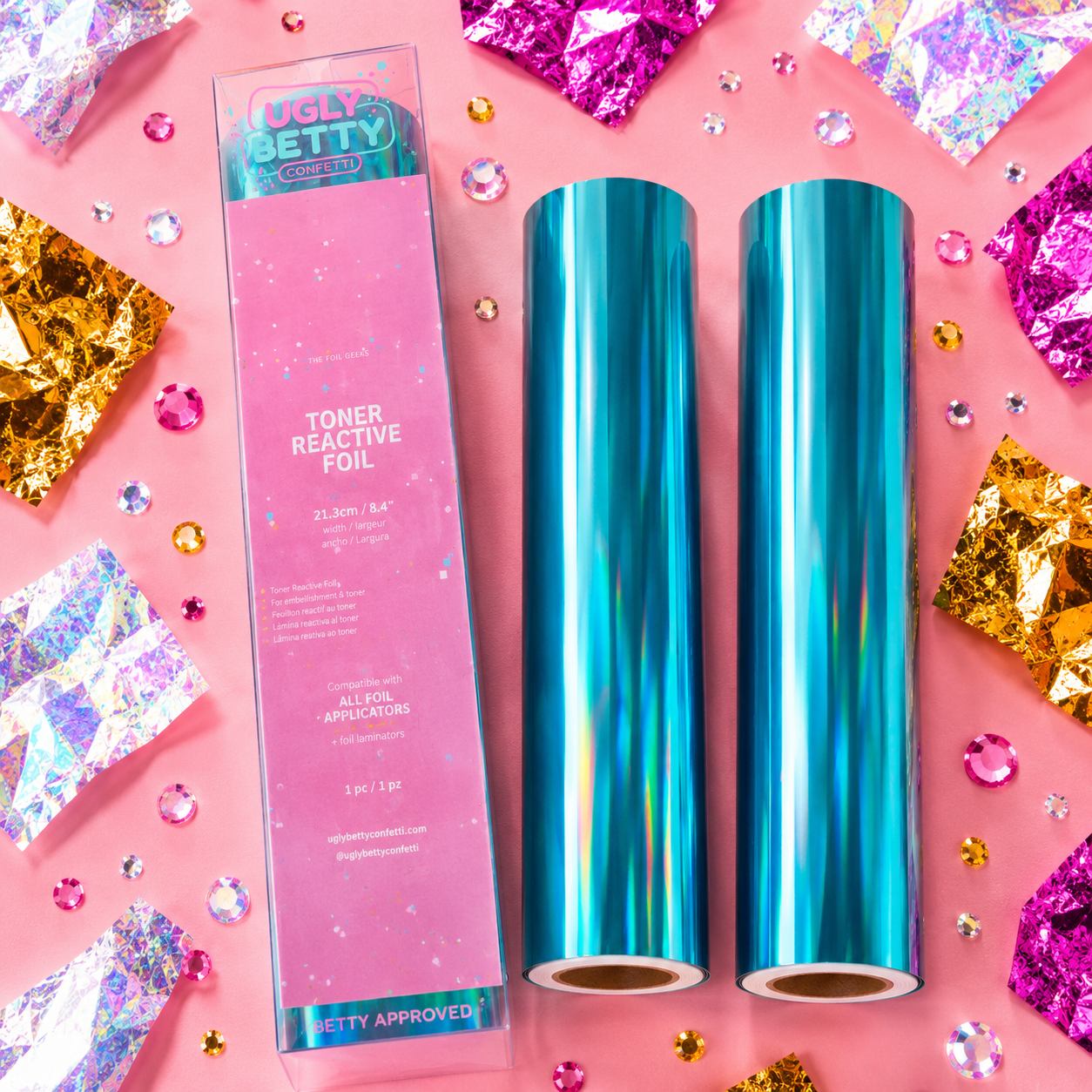 Two rolls of blue toner reactive foil with packaging on a pink background with decorative elements.